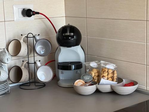 a kitchen counter with a coffee maker and bowls of food at Masseria Parco delle Casette in Alberobello