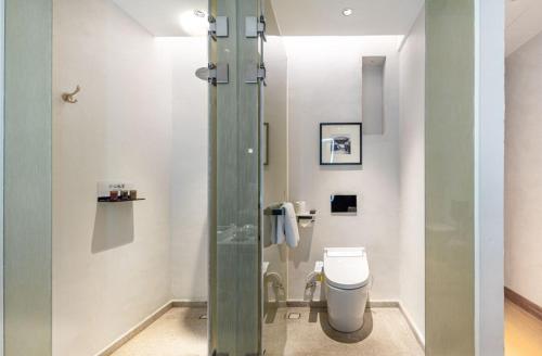 a bathroom with a toilet and a glass shower at Ancient Charm Inn Chengdu in Chengdu