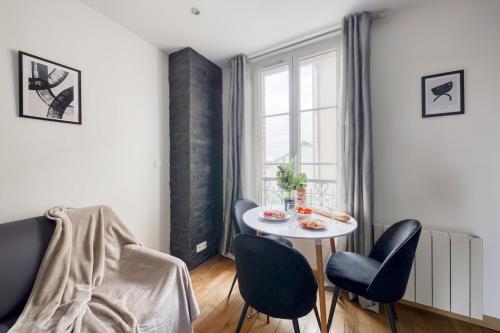 une petite salle à manger avec une table et des chaises blanches dans l'établissement Le Cocon - 5min Paris - 30min Disney - Cosy & Calme, à Fontenay-sous-Bois