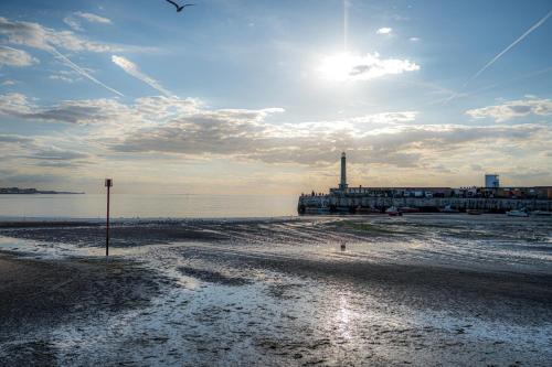 a beach with the sun shining on the water at Lovely house on Trinity Square, edge of Old Town in Margate