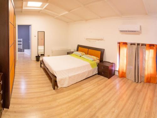 a bedroom with a bed and a wooden floor at La Manovella Apartment in Caselle Torinese