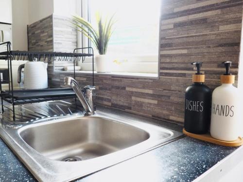 a kitchen sink with two bottles on a counter at Central 3 Bed House with Parking in Oxford