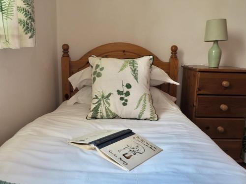 a book sitting on top of a bed with a pillow at Central 3 Bed House with Parking in Oxford
