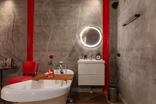 a bathroom with a white sink and a mirror at Masoch. Hotel & Cafe in Lviv