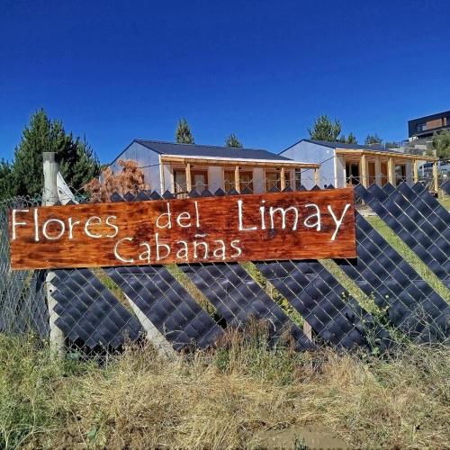 un cartel en una valla delante de una casa en Flores del Limay Cabañas, en Dina Huapi