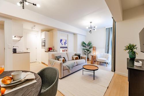 a living room with a couch and a table at Diamant 1BR in Brussels