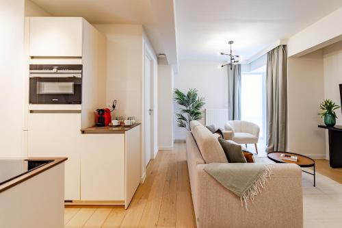 a living room with a couch and a kitchen at Diamant 1BR in Brussels