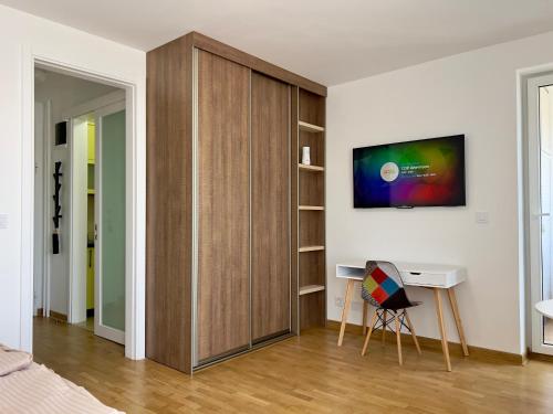 a bedroom with a large wooden cabinet with a desk at Apartment SOFI Belville in Novi Beograd