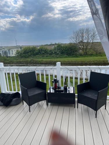 a patio with two chairs and a table on a deck at Lucys Pad in Hull