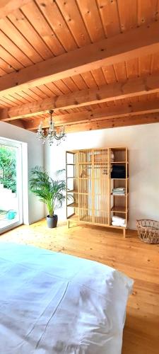 a bedroom with a bed and a wooden ceiling at Das kleine Paradies in Markdorf