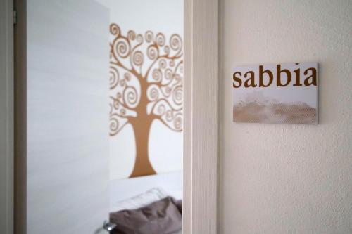 a door with a tree stenciled on the wall at CASAdaMARE in Lido di Jesolo