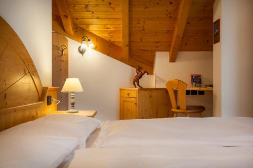 a bedroom with a bed and a desk and a chair at Agritur Bontempelli in Pellizzano