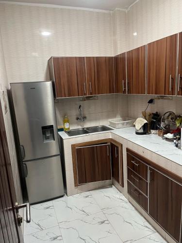 una cucina con mobili in legno e un frigorifero in acciaio inossidabile di Teranga Haven a Dakar