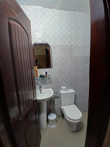 un bagno con un water, un lavandino e uno specchio di Teranga Haven a Dakar