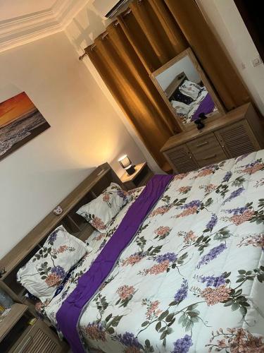 una camera da letto con un letto con dei fiori sopra di Teranga Haven a Dakar