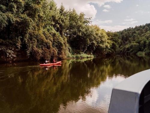 two people in a red boat on a river at Maison au bord de l'eau, Bain nordique in Guipry-Messac