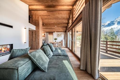 ein Wohnzimmer mit Couch und großem Fenster in der Unterkunft Chalet Foxden, Les Houches Chamonix - by EMERALD STAY in Les Houches