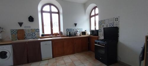 Il comprend une grande cuisine équipée d'une cuisinière et d'un four micro-ondes. dans l'établissement Espace 4 personne , wifi ,parking, à Le Pont-de-Beauvoisin