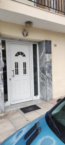 a blue car parked in front of a white door at Σαν Στο Σπίτι Σας in Xanthi