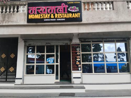 a restaurant with a sign on the side of a building at Makhamali Homestay in Karsiyang
