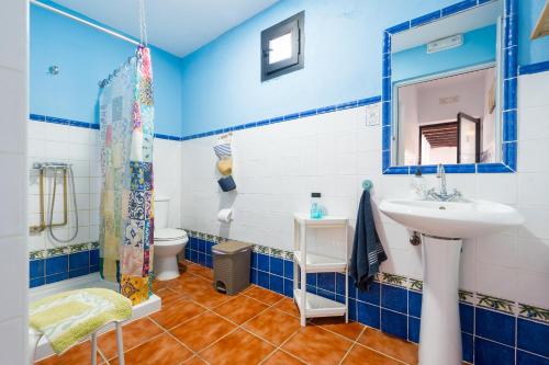 un bagno blu e bianco con lavandino e WC di Puerto Cabero a El Ronquillo