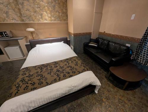 a hotel room with a bed and a couch at Hotel CREST 大人専用 in Amagasaki