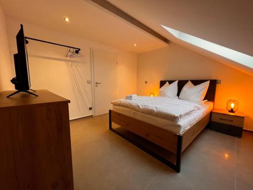 a bedroom with a bed and a flat screen tv at City Apartment 2 in Euskirchen