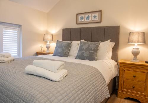 a bedroom with a large bed with two lamps at Olive Lodge Lytham in Lytham St Annes