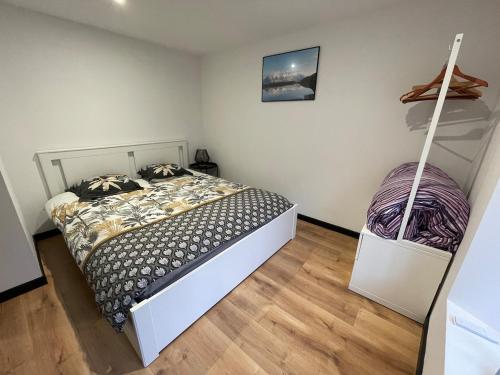 - une chambre avec un lit dans une pièce avec un balai dans l'établissement Appartement 4 personnes au coeur des Pyrénées, à Marignac