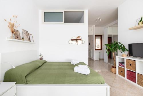 a bedroom with a green bed and a tv at Tiny Boho Chic in Lido di Ostia