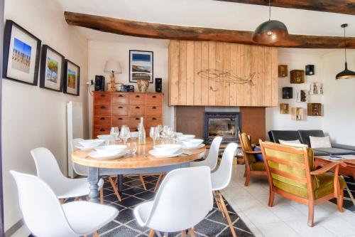 une salle à manger avec une table et des chaises et une cheminée dans l'établissement Maison à 200m de la mer - 6 adultes - 2 enfants, à La Guérinière