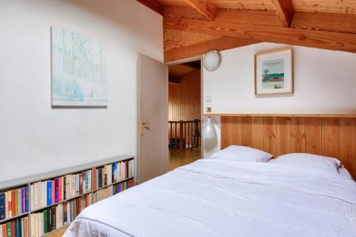 - une chambre avec un lit et une étagère avec des livres dans l'établissement Maison à 200m de la mer - 6 adultes - 2 enfants, à La Guérinière