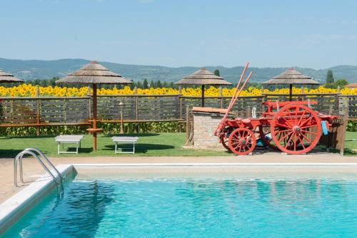 a red wagon sitting next to a swimming pool at TORRE QUADRANA in Spello
