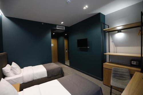 a hotel room with two beds and a tv at Graf Hotel in Tbilisi City