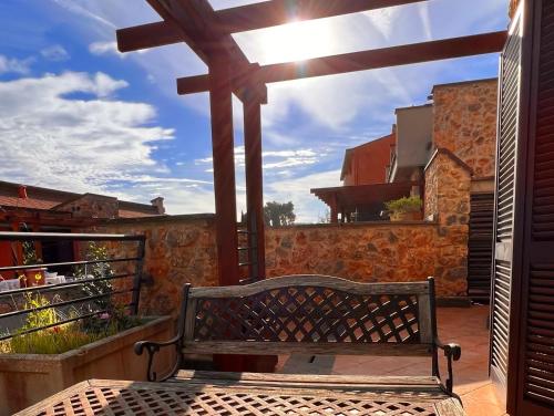 a bench on a balcony with a large wooden cross at Villa La Terrazza in Porto Santo Stefano