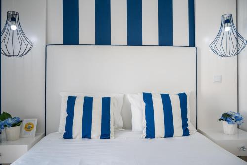 a bedroom with a bed with blue and white stripes at By the Sea - Nazaré in Nazaré