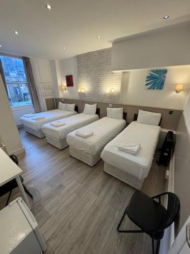 a living room with two beds and a couch at Tony's House Hotel in London