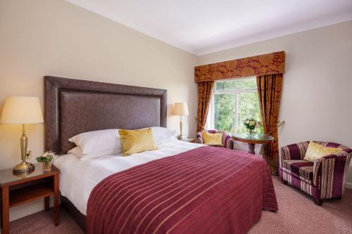 a bedroom with a large bed and a window at Macdonald Kilhey Court Hotel in Wigan