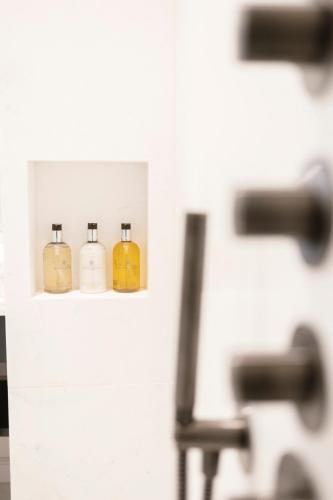three bottles of soap on a shelf in a bathroom at Hotel Boutique Sidonia in Jerez de la Frontera