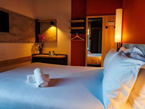 a hotel room with a bed with a towel on it at ibis budget Logroño Centro in Logroño
