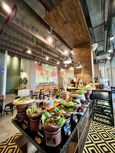 a buffet line with many bowls of food in a restaurant at Hotel Fortunagrande Jember By Fosia Hotels in Jember