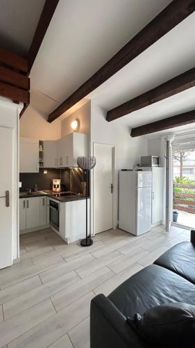 une cuisine avec des armoires blanches et un comptoir dans l'établissement Le Liberty Zen - Proche Camp Naturiste - Terrasse - Parking, au Cap d'Agde