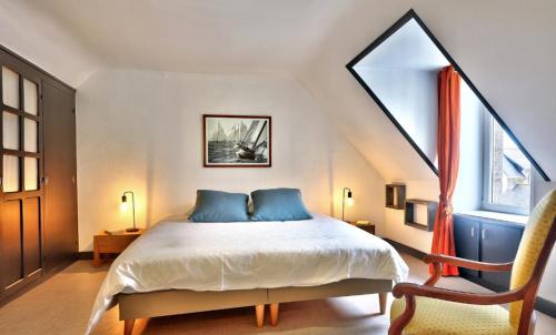 une chambre avec un lit, une chaise et une fenêtre dans l'établissement Magnifique maison pour 9 - Saint Guénolé, à Penmarcʼh