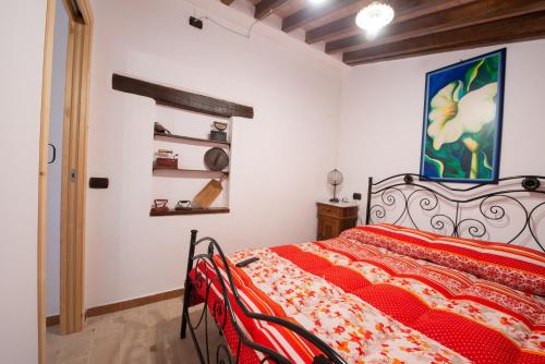 a bedroom with a red bed and a painting on the wall at TORRE QUADRANA in Spello