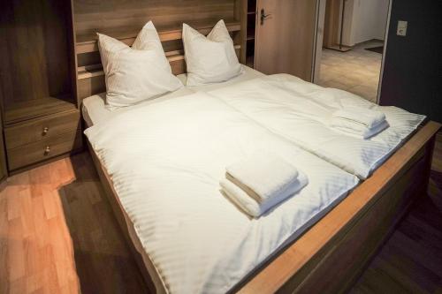 a large bed with white sheets and pillows on it at City Apartment 1 in Euskirchen