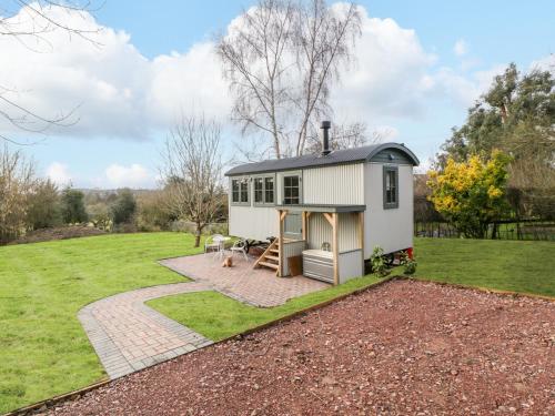 a tiny house in a garden with a patio at Evendine Hut Evendine Cottage in Little Malvern