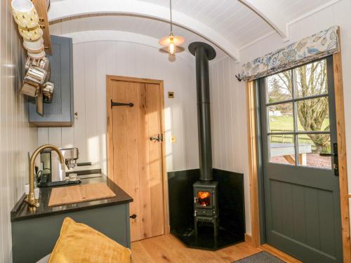 a kitchen with a wood stove in a room at Evendine Hut Evendine Cottage in Little Malvern