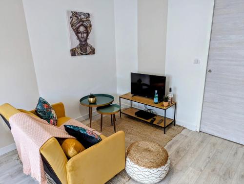 un salon avec un canapé et une télévision dans l'établissement Room Nest, à Bayonne