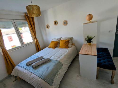 - une chambre avec un lit doté d'oreillers jaunes et d'une table dans l'établissement Room Nest, à Bayonne