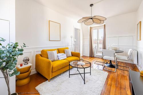 un salon avec un canapé jaune et une table dans l'établissement Apartment 1 Bedroom # Paris 14 # Alesia, à Paris